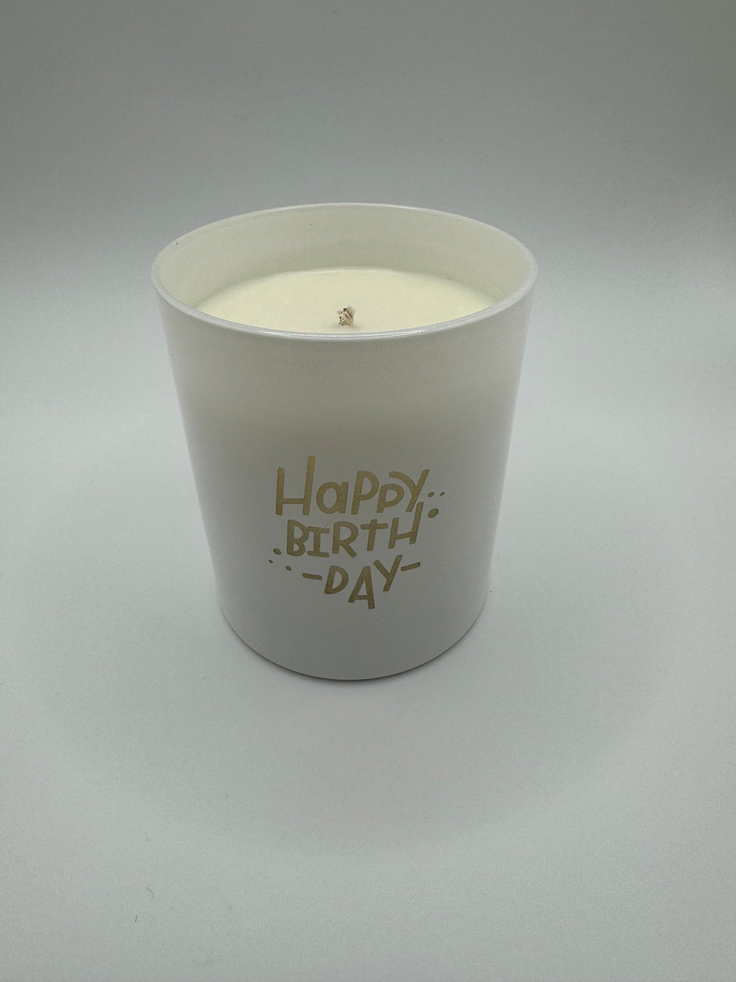 White circular candle jar with Happy Birthday written on the side